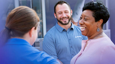 Three people talking to each other and smiling/laughing